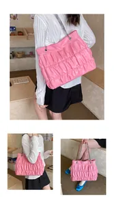Model showcasing a pink ruched tote bag with chain straps in a casual lifestyle setting