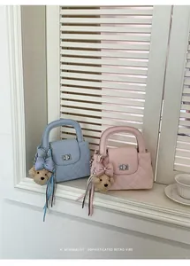 Detailed macro view of quilted mini handbags in pink and blue with teddy charms.