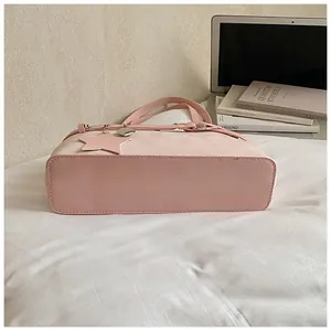 Detailed side view of pink suede tote bag featuring star charm and heart lock detail