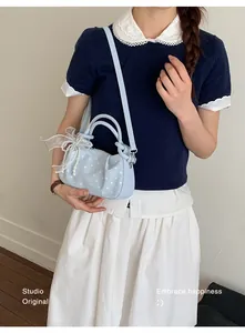Light blue polka dot dumpling bag worn by a model in a lifestyle detail shot.