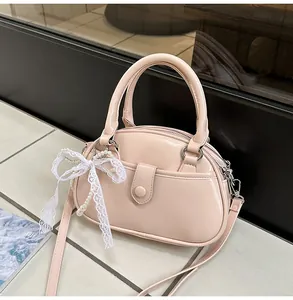 Elegant light pink patent leather handbag featuring lace bow and pearl charm details
