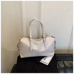 Élégant sac à main oreiller beige avec finition brillante dans un cadre de maison stylé.