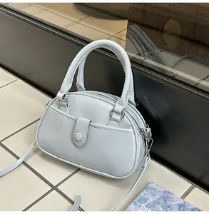 Detailed view of the stylish light blue women's handbag on a modern tiled background.