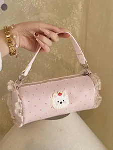 Stylish pink polka dot mini cylinder handbag featuring a cute bear patch and ruffles