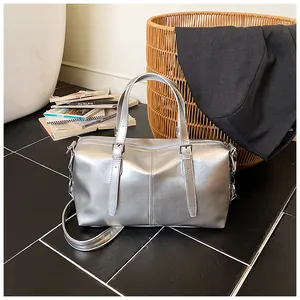 Sac polochon rétro argenté métallisé avec poignées et bandoulière réglable dans un décor