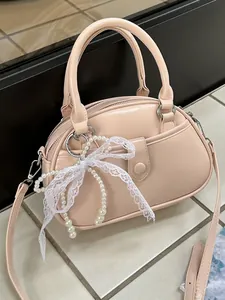 Elegant light pink handbag with a decorative pearl lace bow and crossbody strap