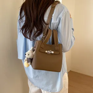 Elegant brown leather bucket bag for women, featured in a stylish crossbody look