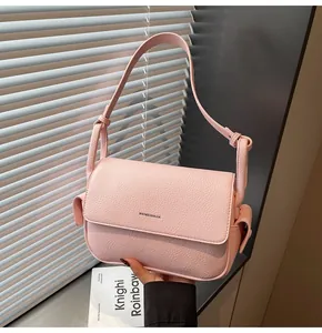 Elegante rosa strukturierte Unterarmtasche aus Leder mit dekorativen Seitentaschen.