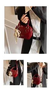 Detail shots of a red glossy leather handbag worn as a tote and crossbody bag