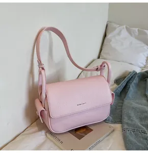 Detailansicht einer rosa Klappentasche aus strukturiertem Leder mit Logo-Detail