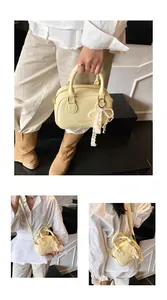 Detailed views of an elegant yellow handbag featuring a pearl and lace bow charm