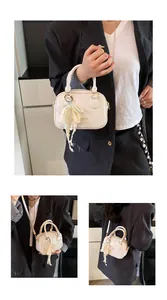 Elegant cream-colored mini handbag with decorative lace and pearl bow charm detail