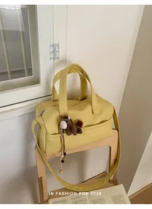 Large yellow pebbled leather crossbody pillow bag with horse charm on chair
