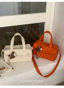 Off-white and orange large capacity crossbody bags with horse charms on a windowsill