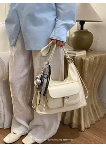 Close-up of a cream-colored large capacity commuter tote bag with silver heart charms