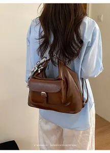 Rear view of a model wearing a minimalist brown leather backpack with retro sophisticated charms
