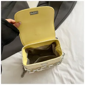 Detailed interior view of a yellow mini chain bag featuring woven straw texture and lining