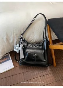 Black versatile large capacity shoulder bag for women with front pocket and charm