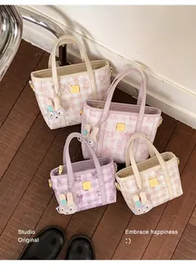 Top-down view of stylish colorful checkered mini handbags arranged on a wooden floor