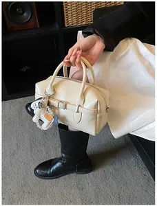 Cream wrinkled Boston pillow bag with pearl animal charm and buckle detail.