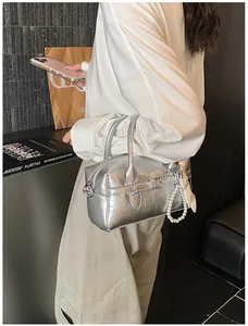 Elegant silver textured Boston pillow bag with a pearl strap, lifestyle detail view.