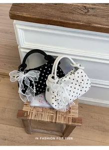 Close-up of polka dot dumpling bags with pearl lace charms on a rustic wicker stool