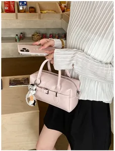 Detail of pink glossy Boston pillow bag with pearl charm, silver hardware, and model