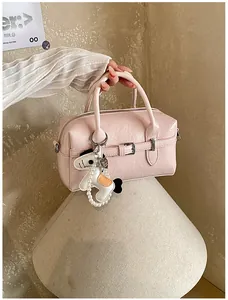 Elegant close-up of a stylish pink Boston pillow bag with a horse charm accessory