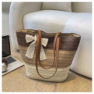 Détail d'un sac cabas en paille tissé à la main avec un nœud en dentelle blanche