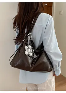 Vista dettagliata di una grande borsa tote marrone in ecopelle indossata da modella.