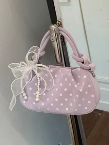 Elegant light purple polka dot handbag with delicate white bow and pearl charm decoration.