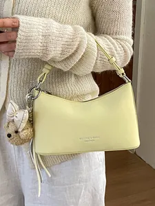 Elegant pale yellow baguette shoulder bag with cute plush teddy bear charm for women