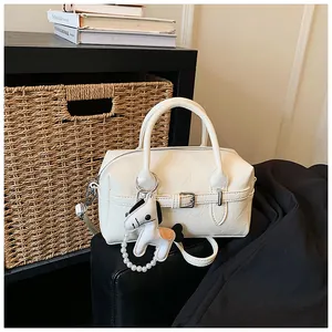 Detailed view of the cream white Boston pillow bag with a horse-shaped pearl charm