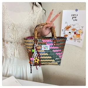 Bolso de cesta tejido a mano con asas de bambú y colgantes de estrellas de colores