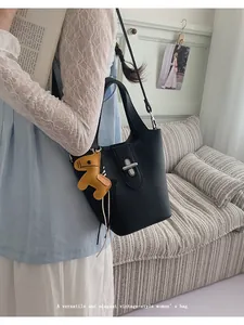 Detailweergave van elegante zwarte leren emmer tas met paardenbedel