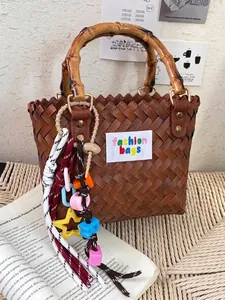 Bolso capazo de paja trenzada marrón con asas de bambú para vacaciones