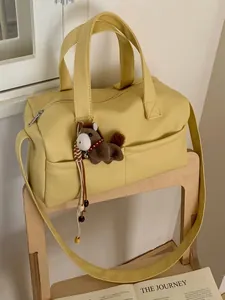 Yellow pebbled leather pillow tote bag with wide strap and horse charm accessory