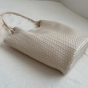 Close-up of beige woven leather tote bag with intricate texture for commuting