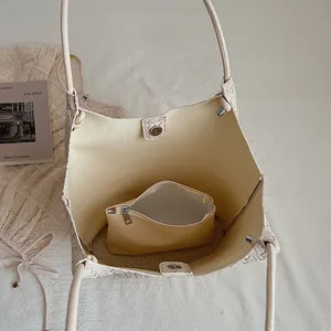 Close-up of the spacious woven tote bag interior featuring a matching cream inner pouch