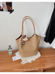 Woven tan tote bag with cute bear charm shown in a cozy home lifestyle setting
