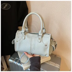 Light blue litchi-textured handbag featuring elegant stitching and metal rivet details
