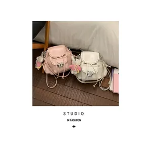 Close-up of sweet style mini backpacks in pink and white with cute rabbit charms.