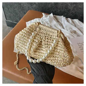 Close-up of vintage pleated straw bag with elegant pearl handle and metal chain strap