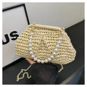 Detail view of woven shell bag with elegant large pearl handle and gold chain strap