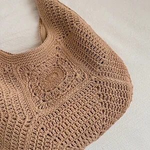 Close-up detail of the intricate hollow crochet pattern on the woven straw bag.