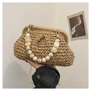 Detailed close-up of vintage straw woven shell clutch with marble beaded handle