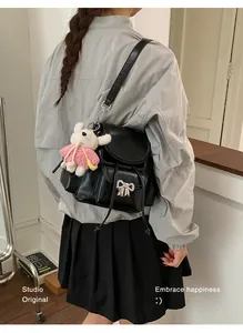 Sweet black backpack for girls with cute bow and rabbit charm detail on model