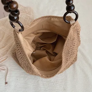 Close-up showing the spacious fabric-lined interior and pockets of the woven straw beach bag