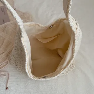 Detail view of the cream woven straw bag interior showing fabric lining and magnetic clasp