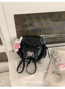 Detailed view of sweet black mini backpack with silver bow and plush rabbit charm.